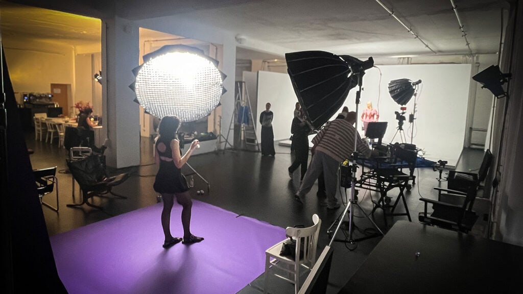 Vibrant photoshoot studio with professional lighting equipment for dynamic visual content creation. Behind the scenes of a video production or photo shoot at NOFOMO.TV, capturing creative processes and high-quality media production.