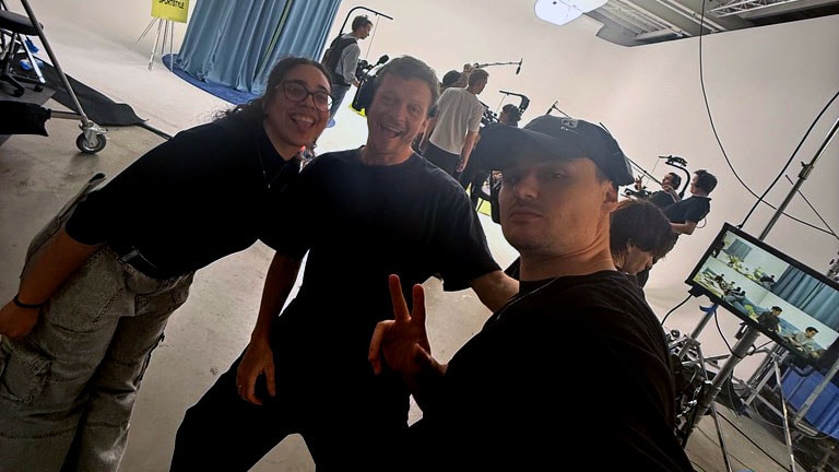 People on set of NOFOMO.TV filming in a studio environment, with professional lighting, cameras, and crew members, showcasing a dynamic media production scene.